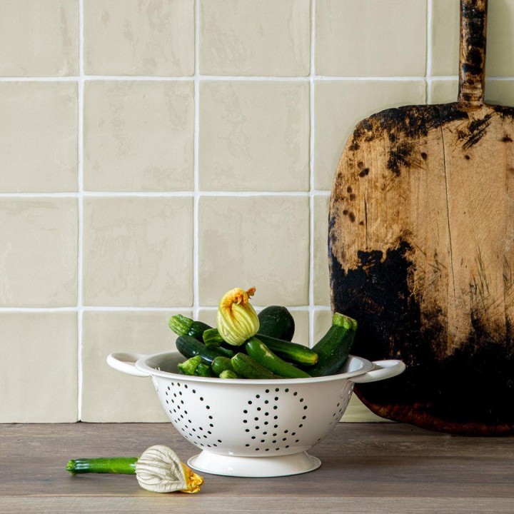 light green contemporary classics portland stone green square wall tiles with a wooden chopping board and colander of courgettes in front